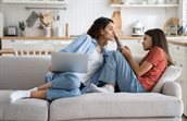 moeder met laptop op de bank met dochter