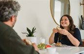 vrouw eet boterham aan tafel