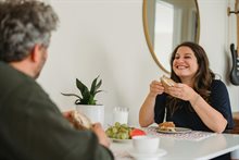 vrouw eet boterham aan tafel